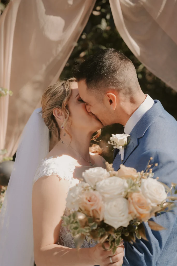 Fotógrafo de bodas en Moli Xirles, los novios besándose con el paisaje del lugar de fondo.