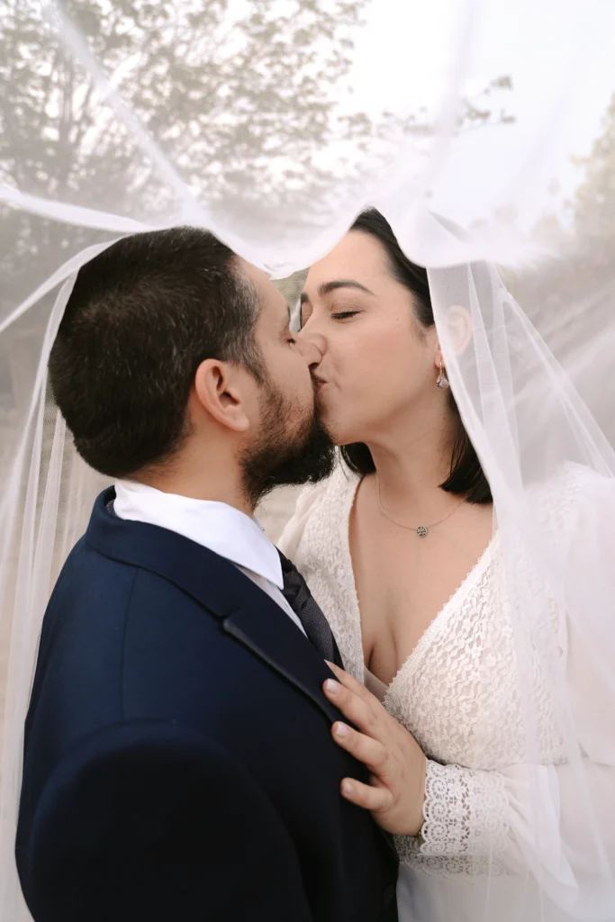 Fotógrafo de postboda en los Ojos del Segura, los novios besándose a través del velo con un toque de luz.