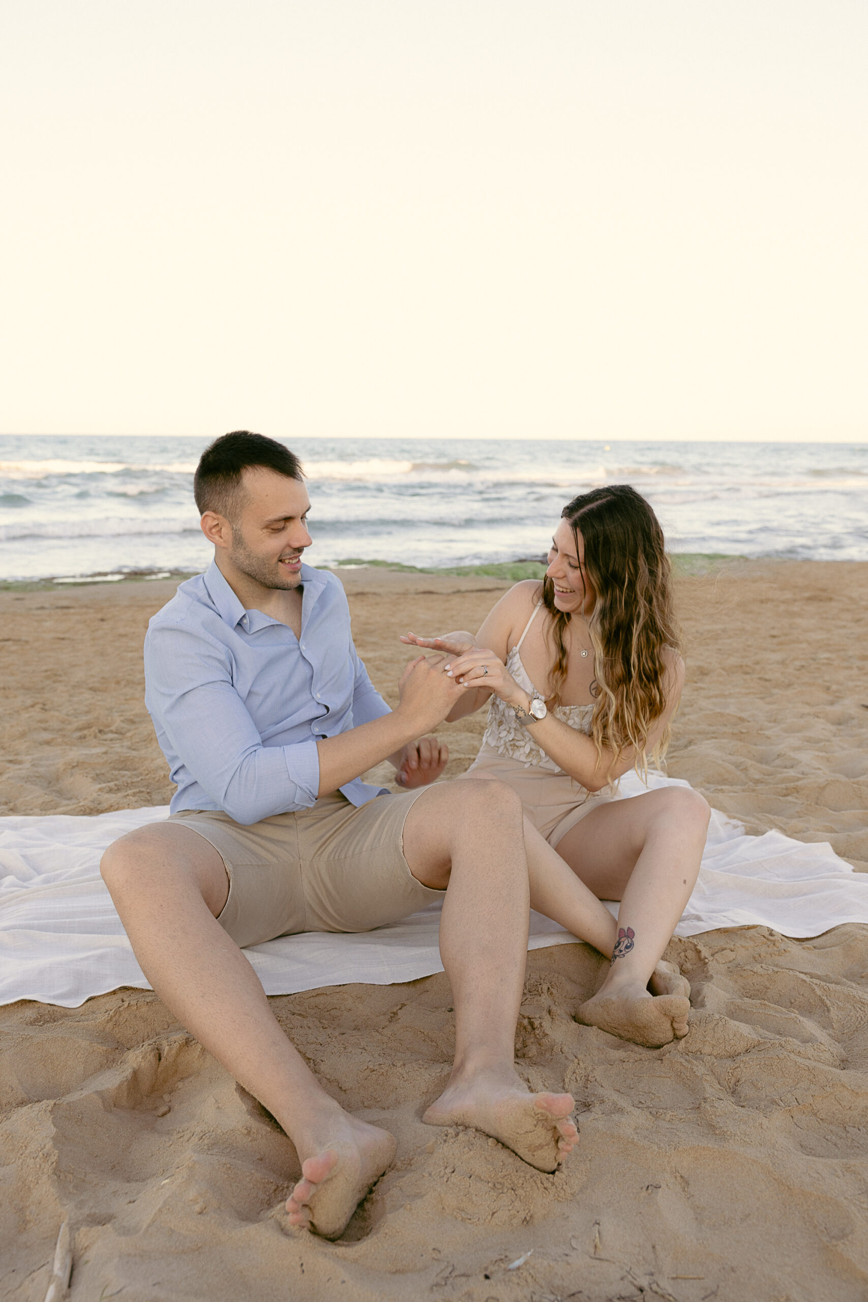 Pareja sentada en la arena de la playa de Guardamar del Segura durante el reportaje de preboda en Orihuela