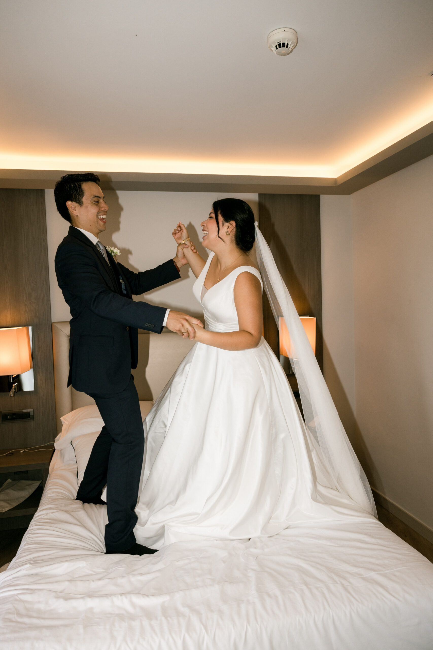 Novios bailando encima de la cama del hotel Melia de Alicante reportaje de boda Sergio Bodas